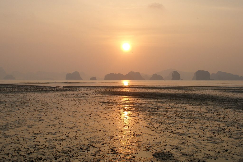 Auringonnousu Phang Ngan lahden kalkkikivisaarten yllä Koh Yao Noin rannalta laskuveden aikaan