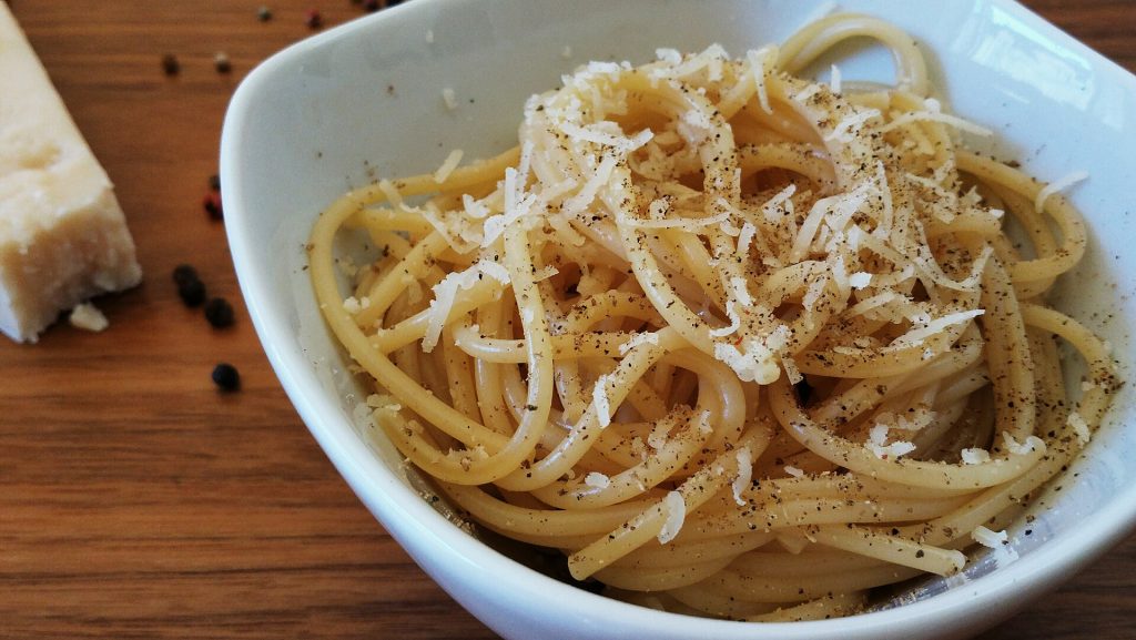 Kulhollinen cacio e pepe -pastaa pecorinojuuston ja mustapippurin kera