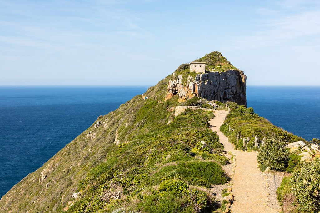 Polku nousee Cape Pointin kärkeen, jossa seisoo vanha majakka meren yllä