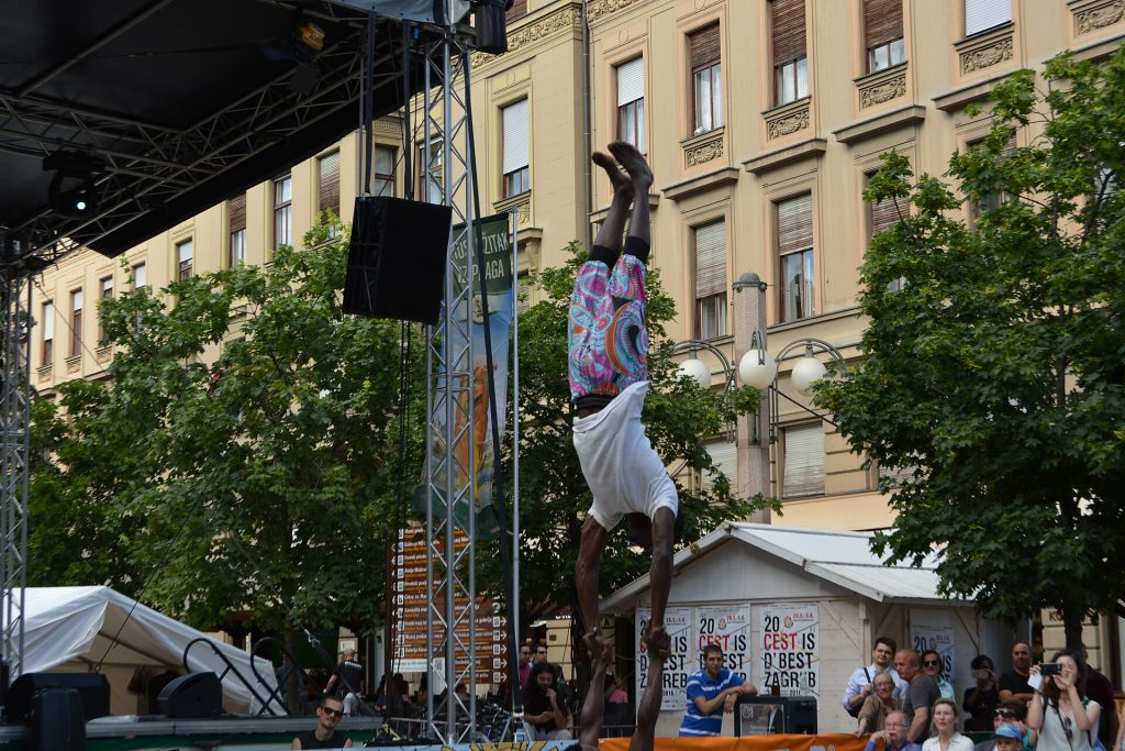 Akrobaatti esiintyy korkean tangon päällä puiden keskellä Zagrebin katutaidefestivaalilla