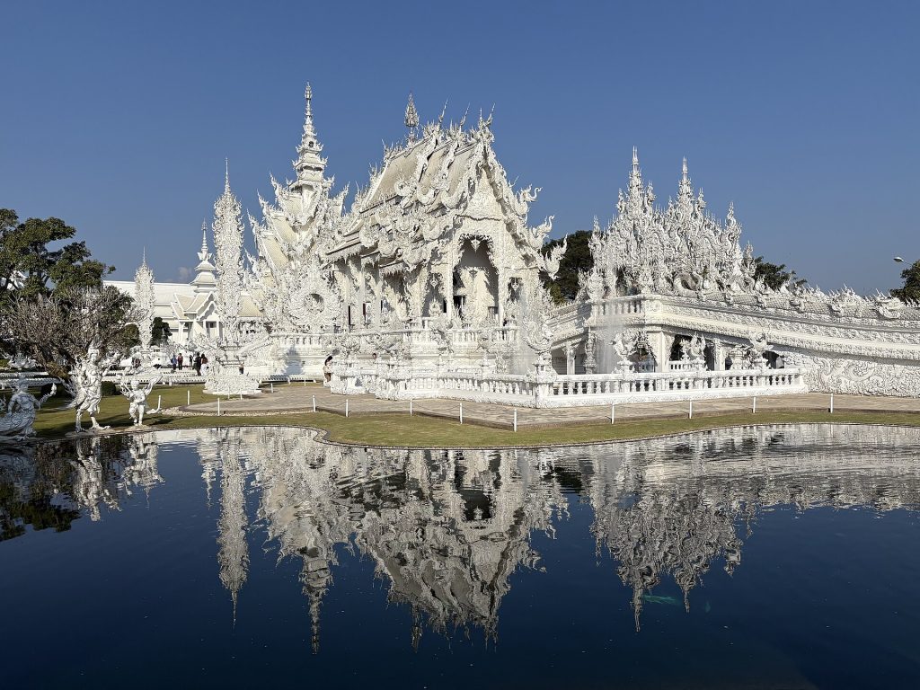 Valkoinen temppeli Wat Rong Khun heijastuu lammen pintaan Chiang Raissa