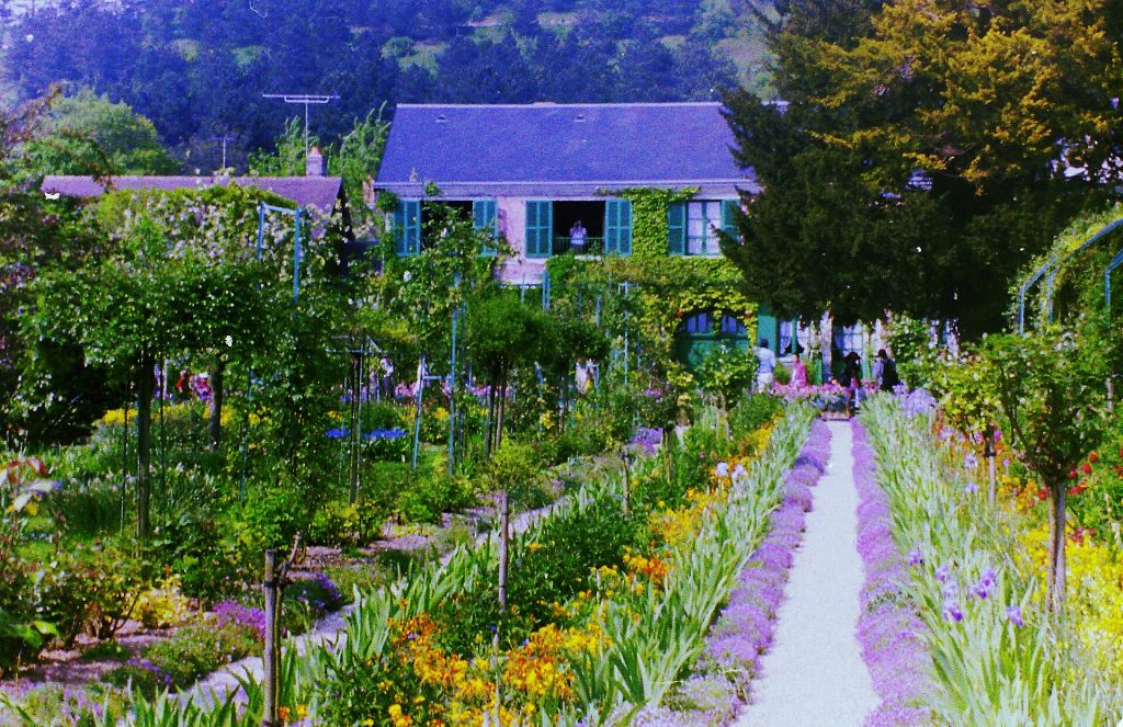 Kukkapenkkien reunustama käytävä Claude Monet’n talolle Givernyn Clos Normand -puutarhassa