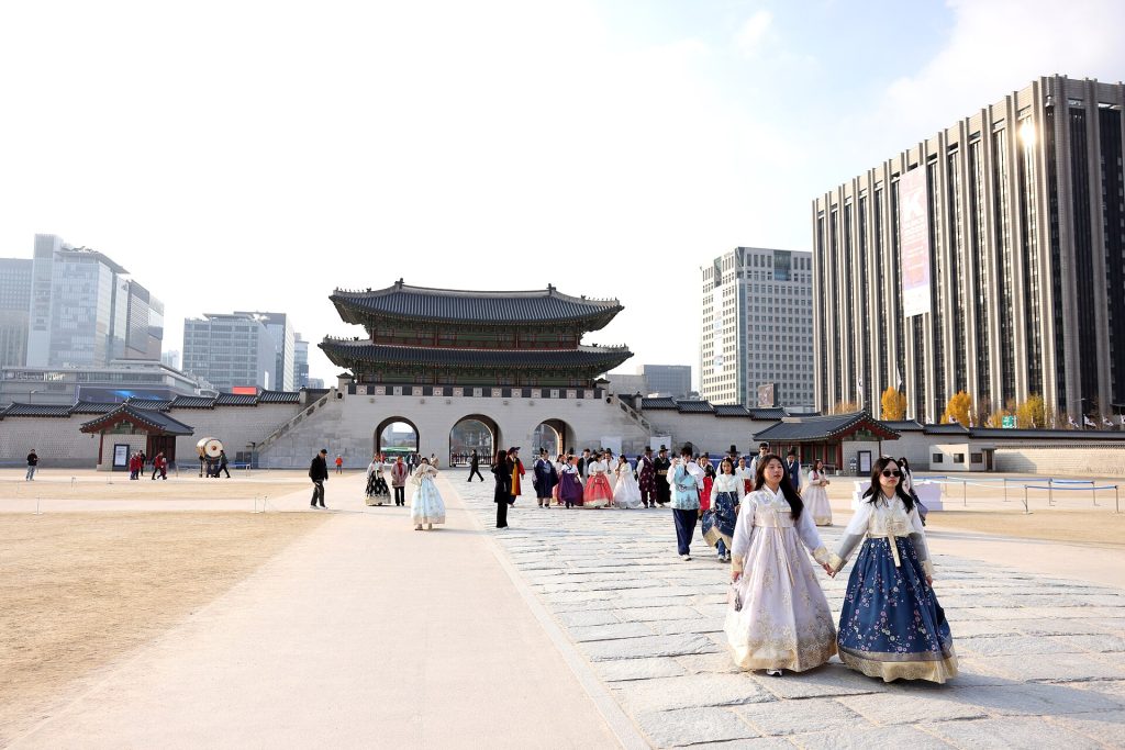 Hanbok-asuisia kävijöitä Gyeongbokgungin palatsin pihalla Soulissa