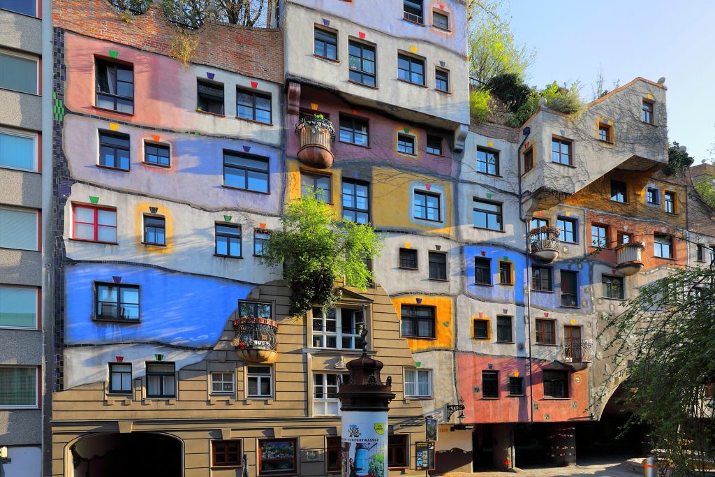 Hundertwasserhausin värikäs ja kasvillisuuden peittämä julkisivu Wienissä