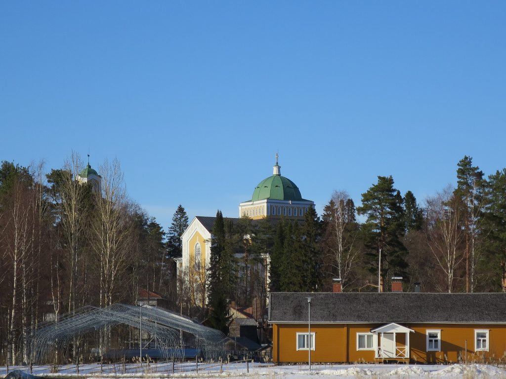 Kerimäen puukirkko kupoleineen jäätyneen järven takana
