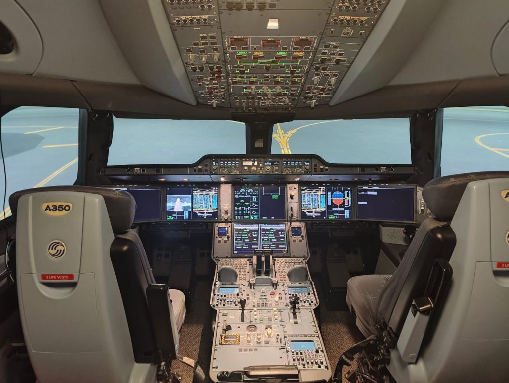 Airbus A350 -lentosimulaattorin ohjaamo näyttöineen ja lentäjien istuimineen