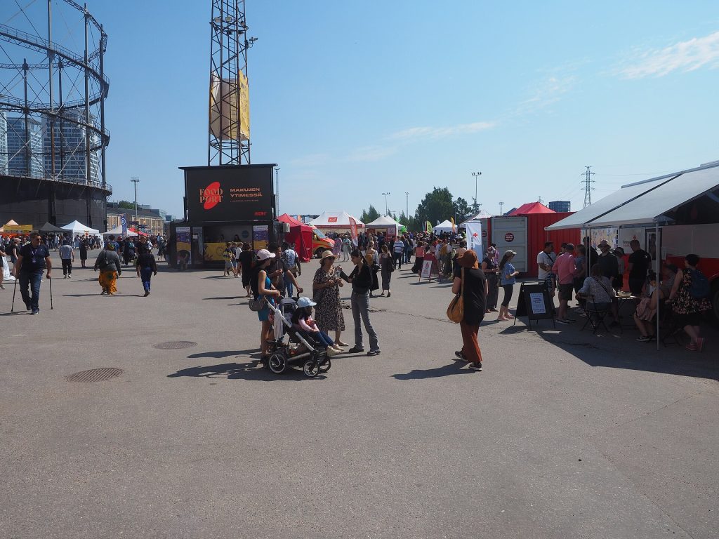 Maailma kylässä -festivaalin aluetta Suvilahdessa, kävijöitä ja kojuja kaasukellon lähellä