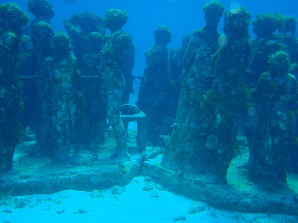 Vedenalaisen MUSA-museon ihmishahmoisia veistoksia hiekkapohjalla Cancúnin edustalla