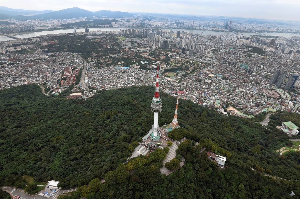 Ilmakuva metsäisestä Namsan-vuoresta ja N Seoul Towerista Soulin keskellä