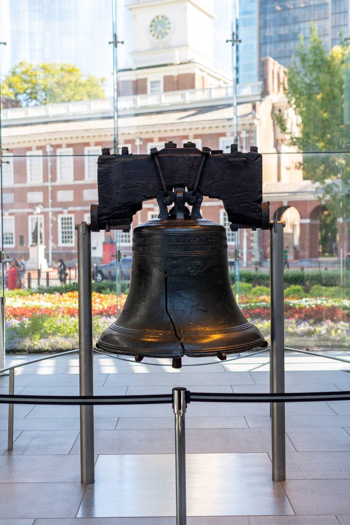 Vapaudenkello Liberty Bell Centerissä, taustalla Independence Hall
