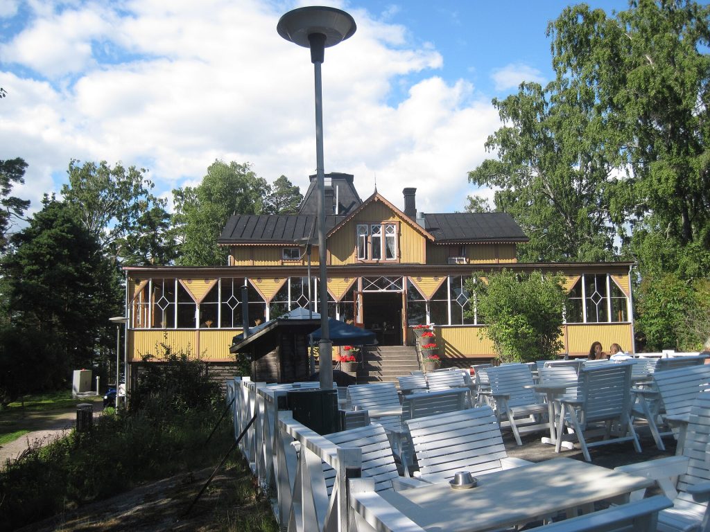 Pihlajasaaren ravintolan vanha huvilarakennus ja terassi kesällä
