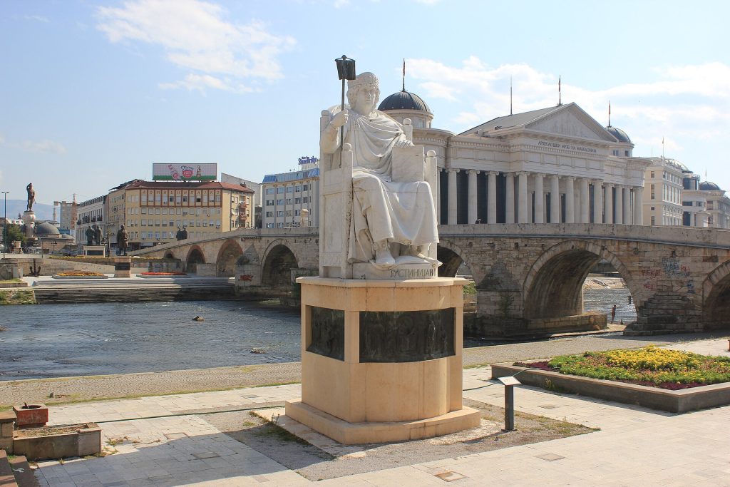 Skopjen Kivisilta Vardar-joen yli ja Skopje 2014 -hankkeen patsaita ja uusklassisia rakennuksia