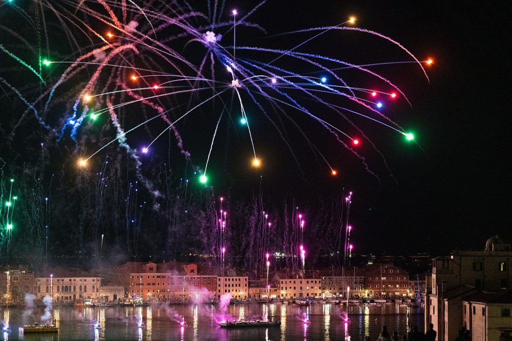 Värikäs ilotulitus Pyhän Markuksen altaan yllä Festa del Redentoren yönä