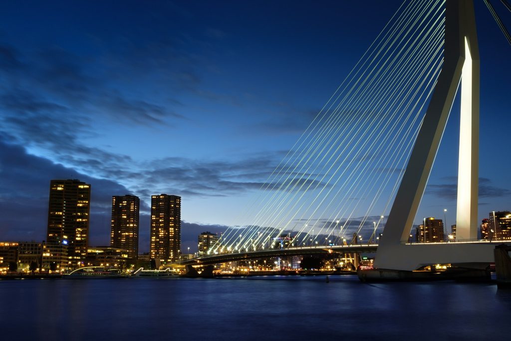 Erasmus-silta ja Rotterdamin pilvenpiirtäjät iltahämärässä Maas-joen yllä
