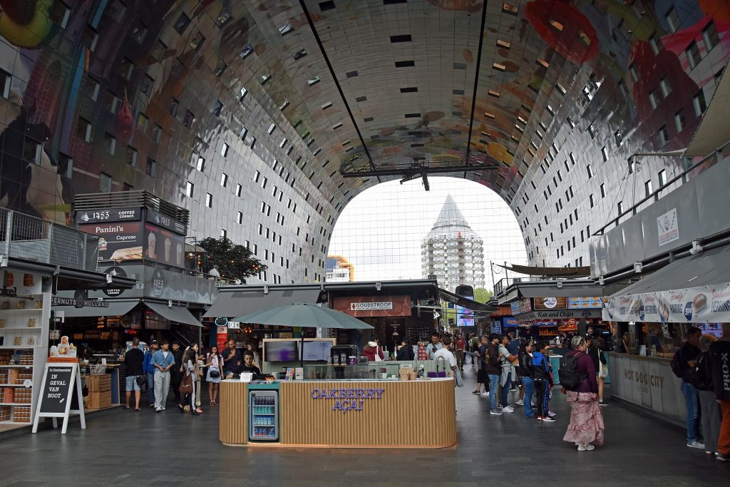 Markthal-kauppahallin kaareva sisätila ja värikäs kattomaalaus Rotterdamissa