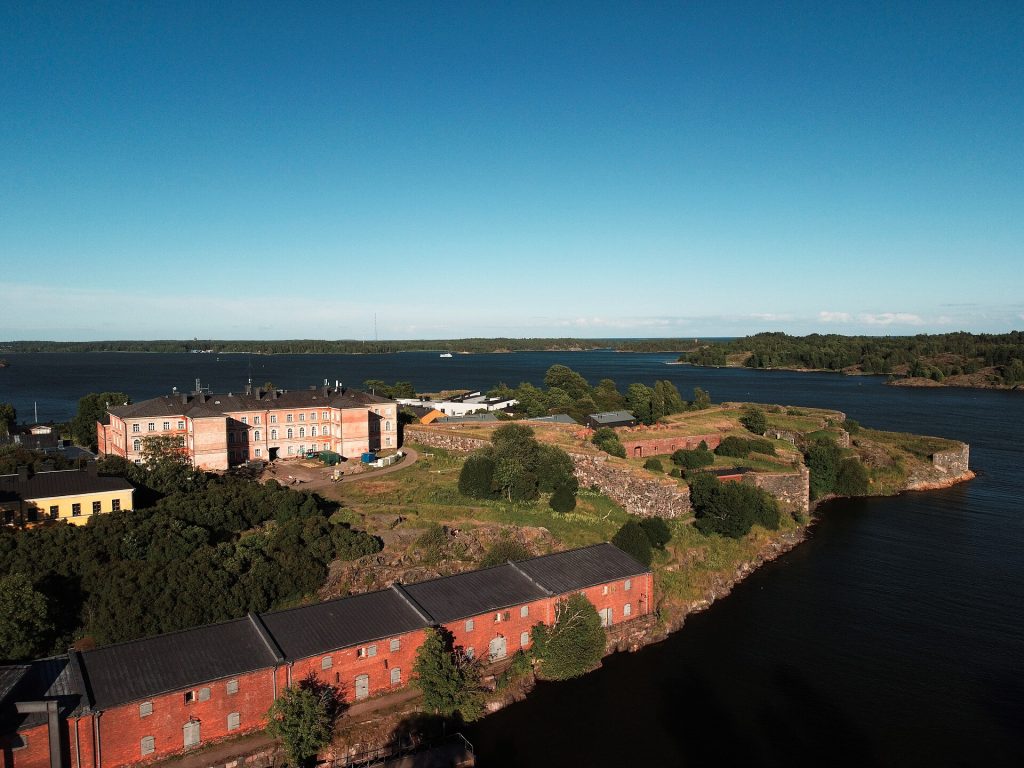 Suomenlinnan vallit ja rakennuksia aurinkoisena kesäpäivänä merta vasten