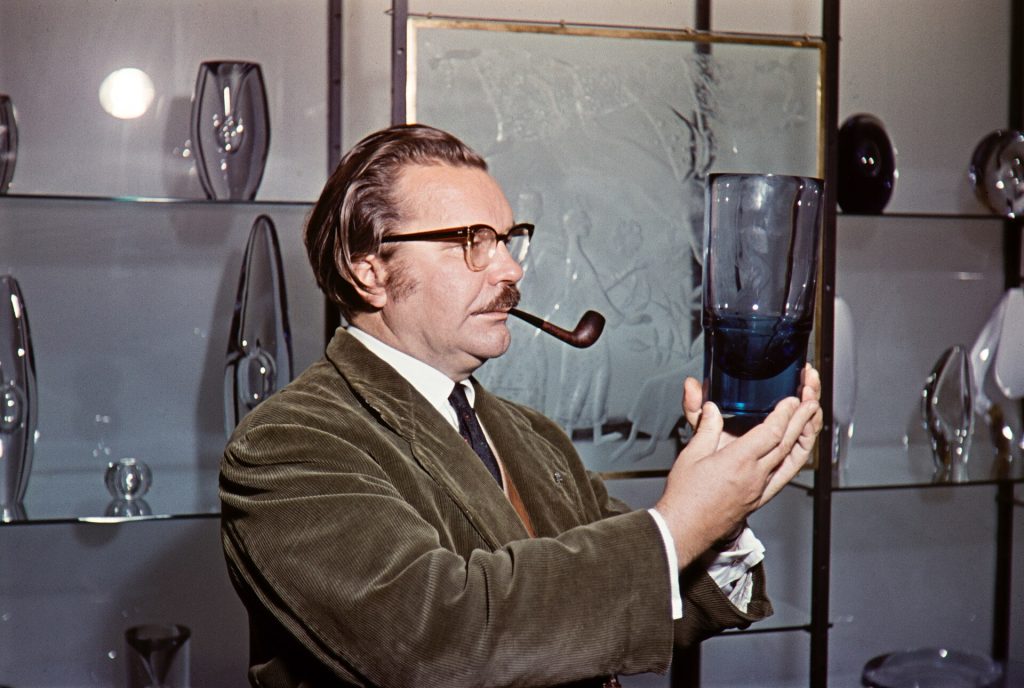 Muotoilija Tapio Wirkkala tarkastelee lasiesinettä Iittalan lasitehtaalla 1950-luvulla
