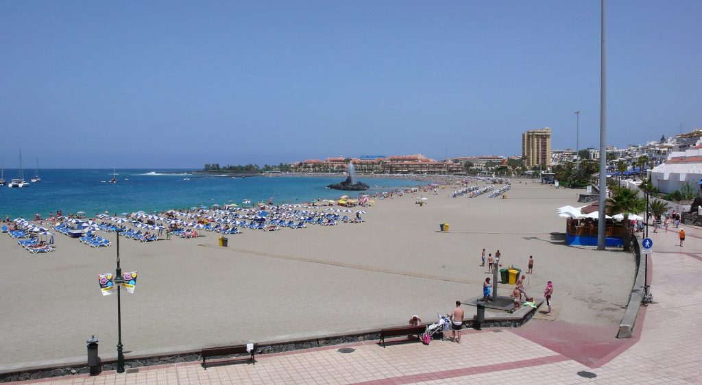 Vaalea hiekkaranta aurinkovarjoineen ja tyyni meri Playa de las Vistasilla Los Cristianosissa Teneriffalla