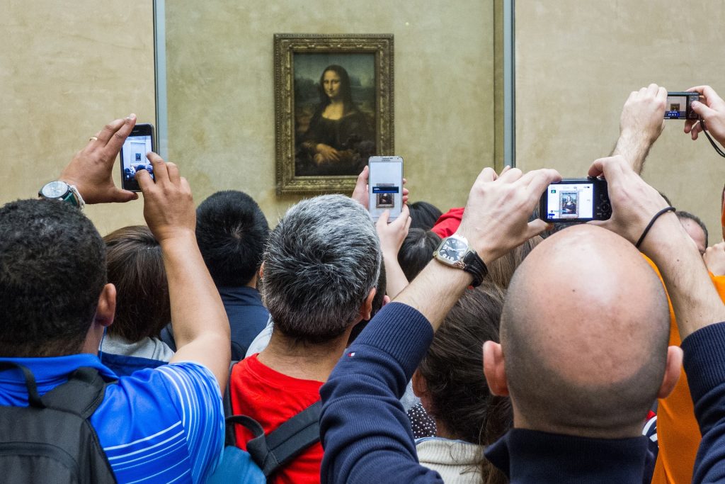 Museovieraiden tungos kuvaamassa Mona Lisaa Louvressa